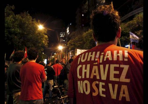 Reuters - Un partidario del presidente de Venezuela, Hugo Ch&#225;vez lleva una camiseta que dice &quot;Ch&#225;vez no se va&quot;, cante el anuncio de su muerte frente a la embajada de Venezuela en Buenos Aires.
