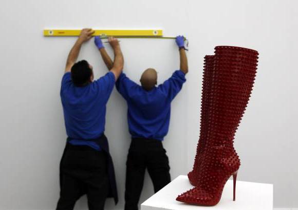 RE - Empleados de Sotheby&#39;s trabajan en la que ser&#225; la subasta llamada Rojo. Las botas Christian Louboutin hacen parte de la exhibici&#243;n.