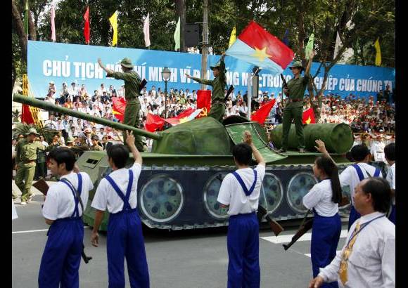 AP - Miles de personas agitaron sus banderas y saludaron a las r&#233;plicas de los carros de combate que desfilaron por las calles de Ho Chi Minh.