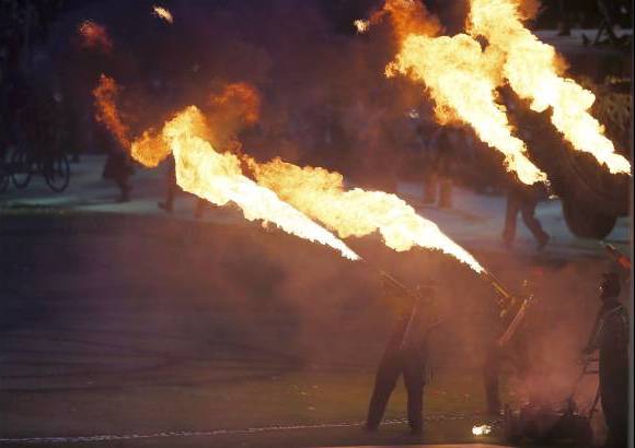 Reuters - La denominada Fiesta de la Llama, presidida por Philip Craven, y el príncipe Eduardo de Inglaterra, el hijo menor de la reina Isabel II, hizo honor a su nombre justo al empezar con decenas de voluntarios haciendo ondear bolas de fuego en un inicio algo gótico y oscuro.