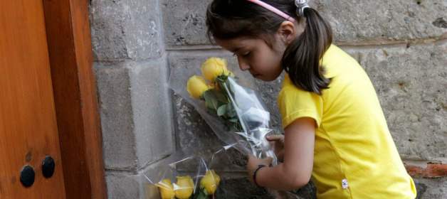 Una niña pone rosas amarillas como ofrenda en la puerta de la casa del premio nobel colombiano Gabriel García Márquez en la Ciudad de México, este viernes 18 de abril. FOTO REUTERS
