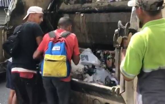 Los jóvenes buscan comida en un camión de basura. FOTO TOMADA DE VIDEO