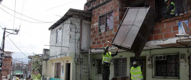 Inseguridad con alto riesgo en seis comunidades de Medellín | En la comuna 16, Belén, la Policía acompañó a una familia para que sacara sus cosas ante el asedio de los combos del sector. FOTO HERNÁN VANEGAS