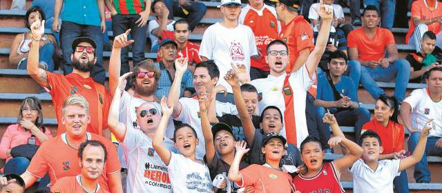 El Envigado tiene una barra de "corte inglés" | La barra Familia Naranja, liderada por hinchas de lengua inglesa, acompaña al Envigado cada que juega en el Parque Estadio Sur con coros de apoyo y una actitud positiva. FOTO MANUEL SALDARRIAGA