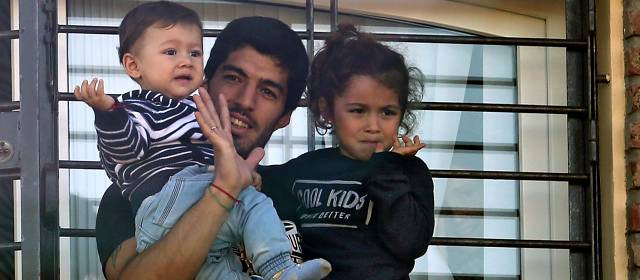 Suárez salió al balcón de su casa y saludó con sus hijos en brazos a un grupo de personas que acababa de entonar el himno nacional. FOTO AFP