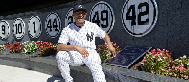Mariano Rivera posa junto a la placa que se le entregó en el Yankee Stadium. En el muro, su retirado número 42. FOTO AP