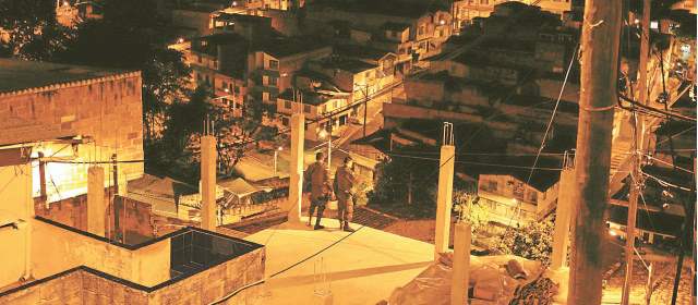 Noches de miedo y soledad en la Comuna 8 | En una terraza del barrio San Antonio, un par de patrulleros de la Policía observa la soledad de la comuna 8, en horas de la madrugada. FOTOS MANUEL SALDARRIAGA.
