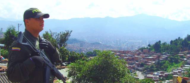 Terror por guerra en la Comuna 8 | Un grupo de policías custodia los sectores Las Granjas, Esfuerzos de Paz y El Ventiadero, en la comuna 8. Al fondo se aprecia el barrio San Antonio. FOTO NELSON MATTA.