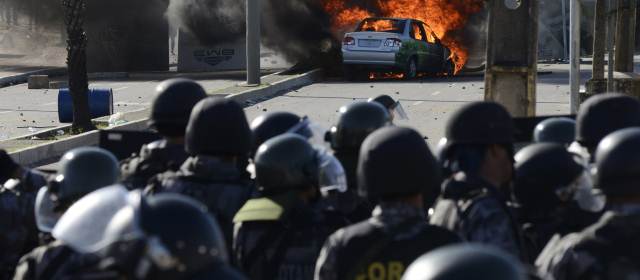 Un vehículo fue incendiado cerca de la policía antidisturbios durante una protesta cerca del Estadio Castelao, donde se jugó el partido de semifinales de la Copa Confederaciones entre España e Italia, en Fortaleza. FOTO REUTERS