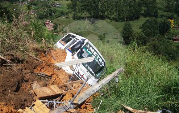 Un bus que pasaba por la vía quedó atrapado por el derrumbe en la vereda Santa Rita del corregimiento de San Antonio de Prado.Equipos de bomberos y Dagrd atendieron la emergencia. FOTO martha arias