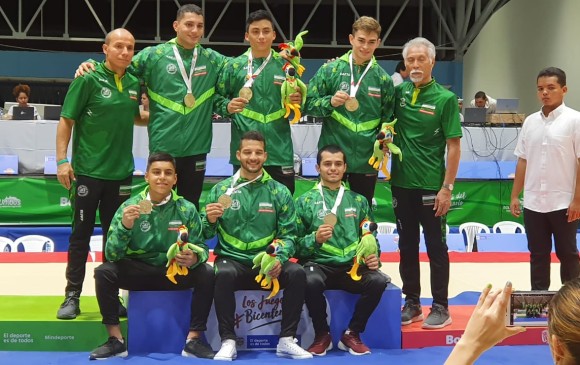 La selección Antioquia de gimnasia artística posa con la medalla de oro junto a sus entrenadores. FOTO cortesía indeportes