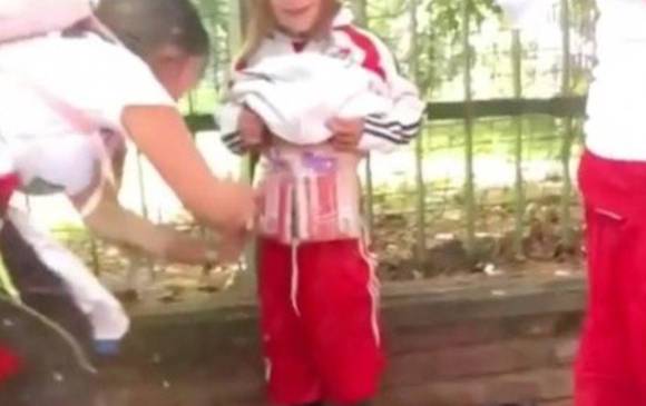 Foto tomada del video que circuló el sábado en la que se aprecia a la mujer poniendo las bengalas en el cuerpo de un menor. FOTO TOMADA DE DIARIO OLÉ