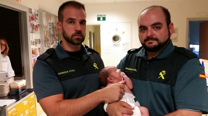 Los agentes Carlos Rodríguez y Andrés Moyano, se tomaron una foto con el bebé tras rescatarlo. FOTO gUARDIA CIVIL ESPAÑOLA 