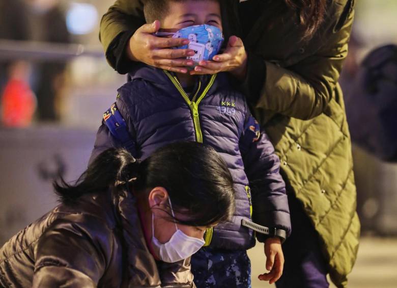 Wuhan: esta es la ciudad origen del virus. Una madre le revisa la máscara a su pequeño hijo a las afueras de la estación de trenes de Hankou. Foto: Efe