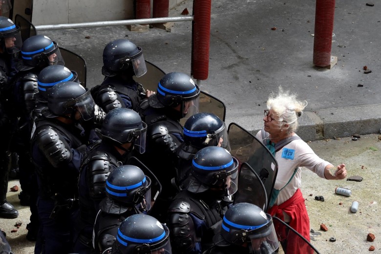 Una mujer se enfrenta a varios policías franceses mientras estos intentan bloquear el acceso a una calle parisina durante la protesta por la reforma laboral en Francia. FOTO AFP