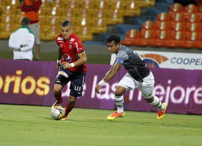 El delantero Leonardo Castro intenta el gol del DIM, pero es bien custodiado por Jéfferson Gómez. Llovió al final. FOTO Jaime Pérez