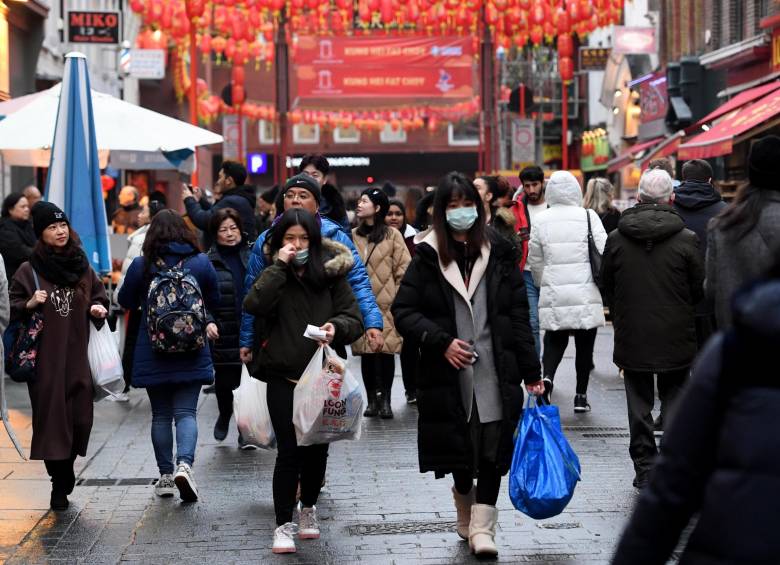 Londres: peatones caminan por las calles del Reino Unido usando tapabocas. Las autoridades monitorearán los vuelos que lleguen desde China. Foto: EFE