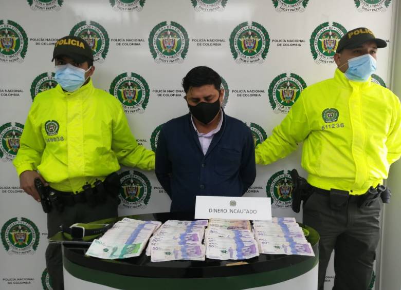 Este es alias “el Tombito”, junto a los $20 millones que le incautaron en el procedimiento de captura, en Bogotá. FOTO: CORTESÍA.