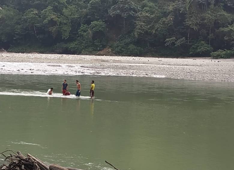 Jóvenes sobre un Jhonson hundido en el Cauca. FOTO MANUEL SALDARRIAGA
