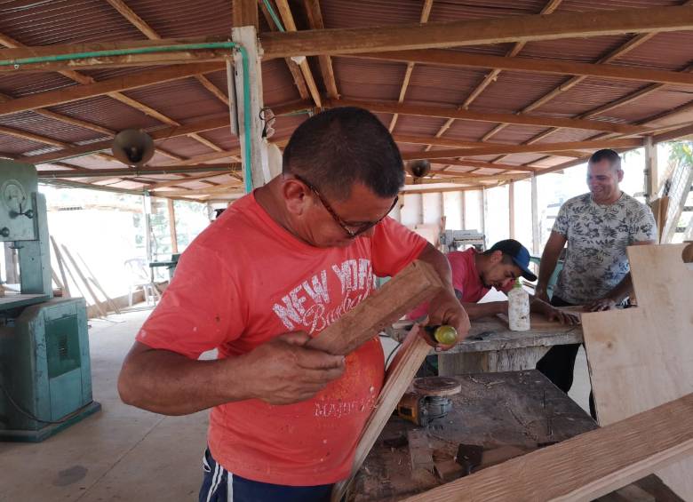 Raúl Méndez y otros dos excombatientes en el taller de ebanistería en Remedios. FOTO cortesía arn