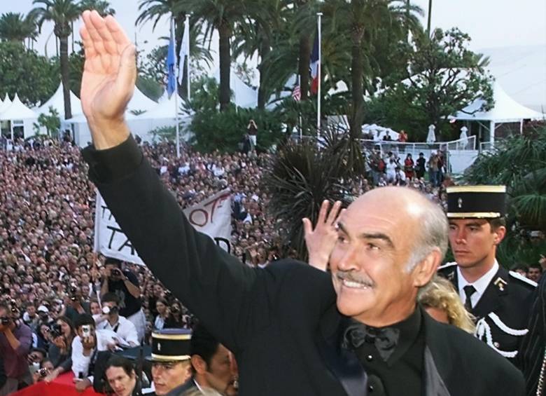 En esta foto de archivo tomada el 14 de mayo de 1999, el actor británico Sean Connery saluda a la multitud en los escalones del Palais des Festivals antes de la proyección de su película “Entrapment” en la selección para el 52 ° Festival de Cine de Cannes Foto: AFP