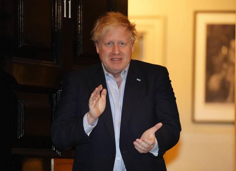Boris Johnson mientras aplaudia al personal médico en la puerta de su residencia el 2 de abril. FOTO AFP