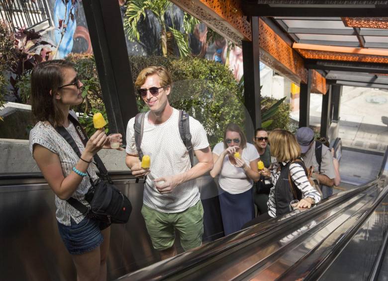Turistas extranjeros en las escaleras eléctricas de la comuna 13 de Medellín. FOTO EDWIN BUSTAMANTE