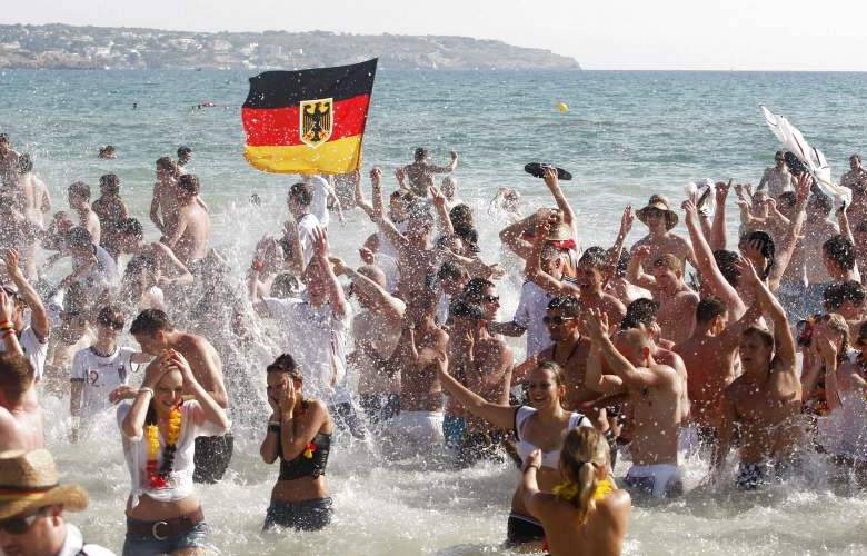 AP - Decenas de hinchas alemanes celebran en una playa de Palma de Mallorca, España, el triunfo de su selección.