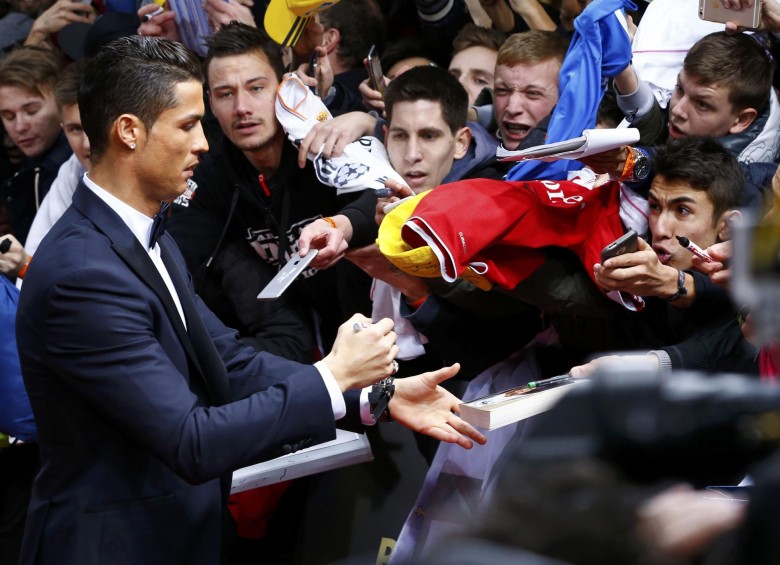 Cristiano Ronaldo, delantero del Real Madrid, firma autógrafos en la alfombra roja previa a la gala del Balón de Oro. FOTO REUTERS