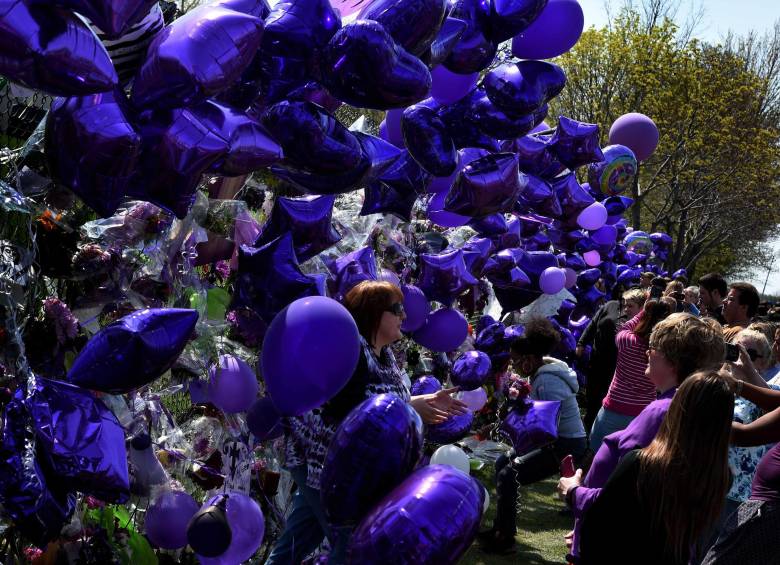 Los fanáticos llevaron globos y flores púrpuras a la residencia del cantante. FOTO AFP