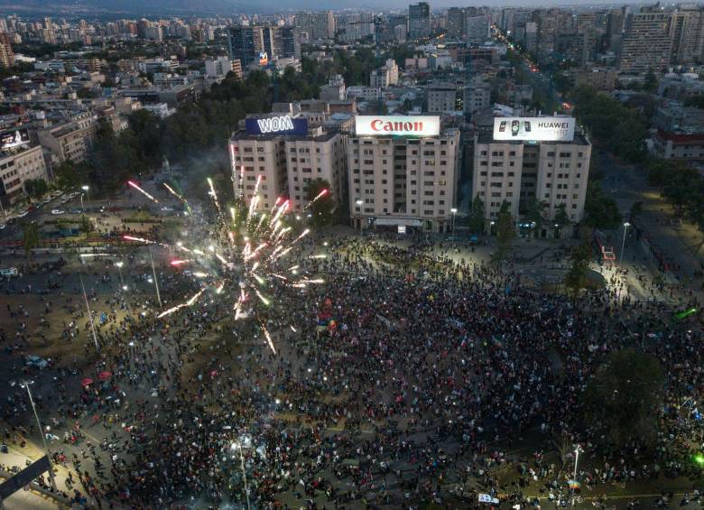 Desde el comienzo de la tarde, la céntrica Plaza Italia de Santiago de Chile se llenó de miles de personas para esperar el resultado del conteo de votos y celebrar desde muy pronto la tendencia que daba la victoria al cambio constitucional. Foto: AFP