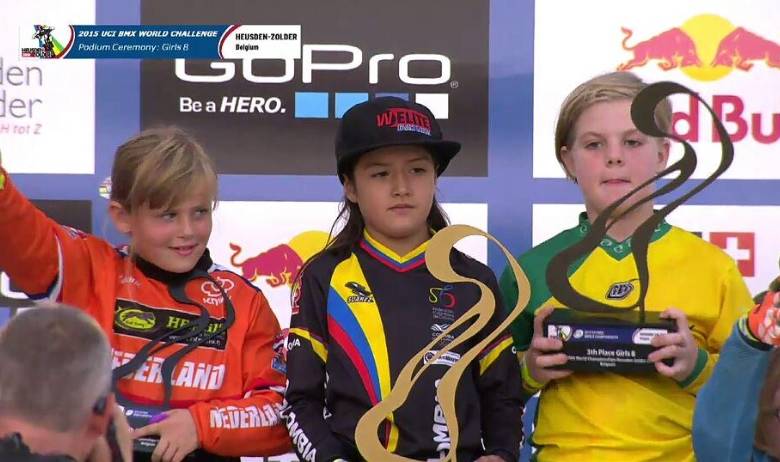 Nicole Foronda (centro), ayer en el podio del Mundial de BMX en Bélgica con el trofeo de campeona mundial. Su sueño de convertirse en la nueva Mariana Pajón va por buen camino. FOTO cortesía