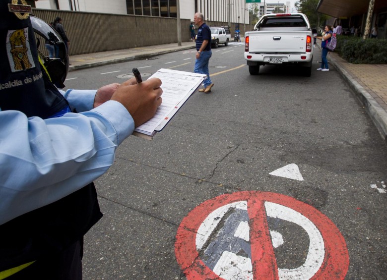 Guardas de tránsito colocan multas en una vía pública. Foto: Jaime Pérez Munévar