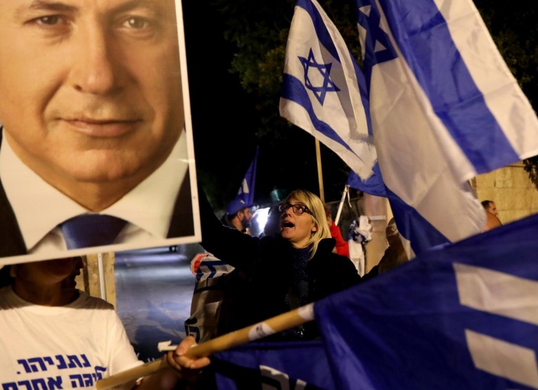 Los partidarios del primer ministro israelí, Benjamin Netanyahu, cantan consignas mientras demuestran su solidaridad con él fuera de su residencia oficial en Jerusalén. FOTO AFP