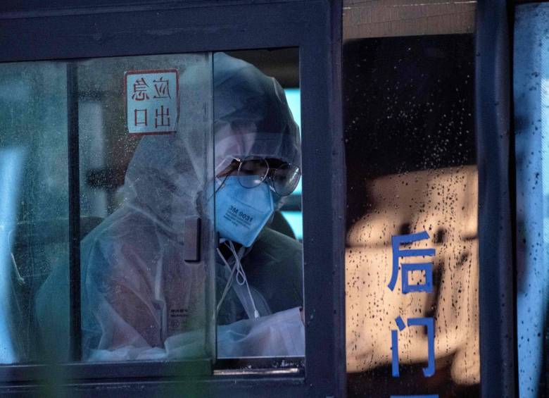 Una mujer que llevaba una máscara facial protectora viaja en un autobús en Shanghai en febrero de 2020. FOTO AFP