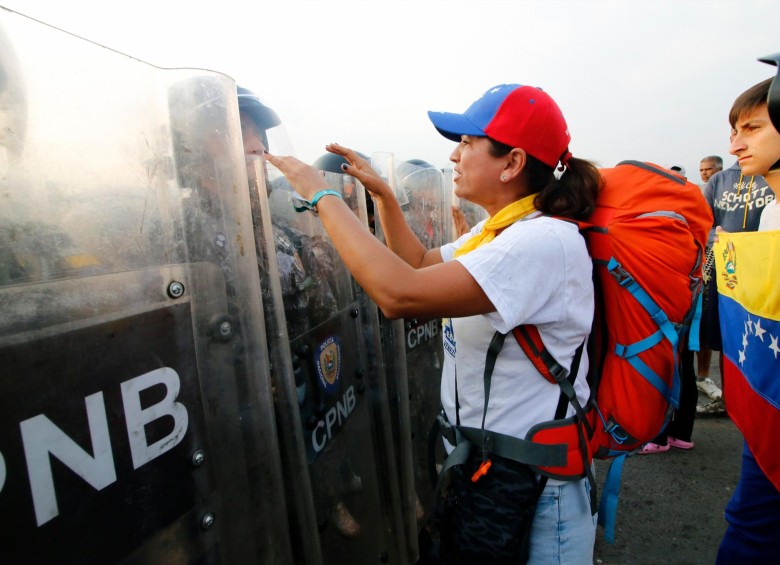 Personas piden a los militares venezolanos el paso de la ayuda humanitaria. FOTO AFP