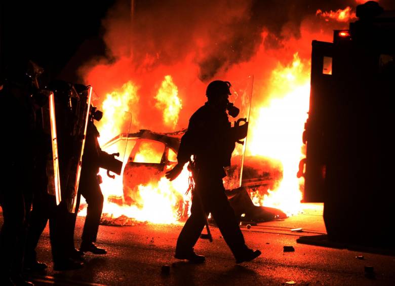 Vehículos y edificios en llamas, con comercios saqueados y enfrentamientos entre manifestantes, se presentaron en Ferguson. FOTO AFP