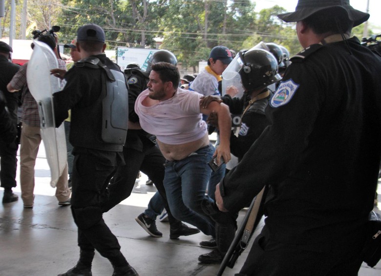 El fotógrafo de la AFP, Luis Sequeira, siendo retenido por la policía nicaragüense durante los desmanes. FOTO AFP.