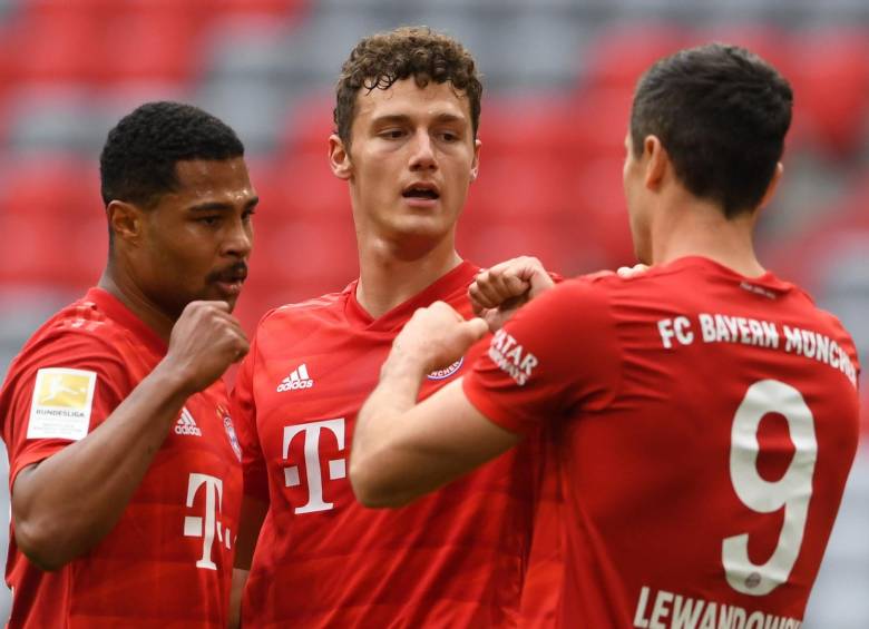 Los jugadores Serge Gnabry, Benjamin Pavard y Robert Lewandowski celebran el primer gol del compromiso en un Allianz Arena completamente vacío. FOTO EFE