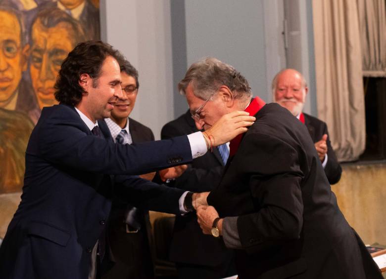 Hernán Gutiérrez recibe una medalla de su hijo Federico Gutiérrez durante el homenaje le hizo a Asociación de Ingenieros Egresados de la Facultad de Minas. FOTO: CORTESÍA