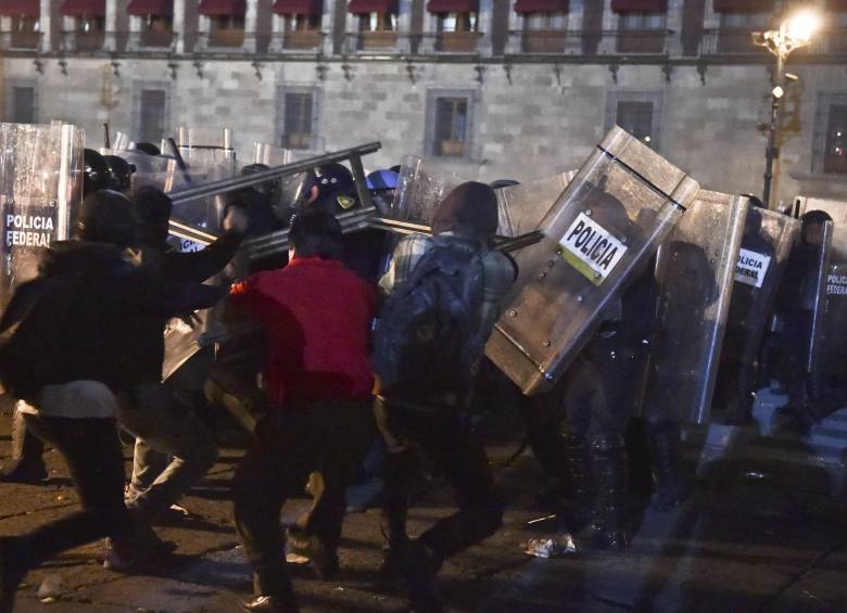 Manifestantes chocaron con la policía el jueves afuera del Palacio nacional, en la última de una serie de protestas pidiendo esclarecimiento de las desapariciones de los estudiantes. FOTO AFP 
