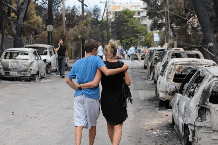 Una pareja camina por las calles de Mati, Grecia. FOTO EFE