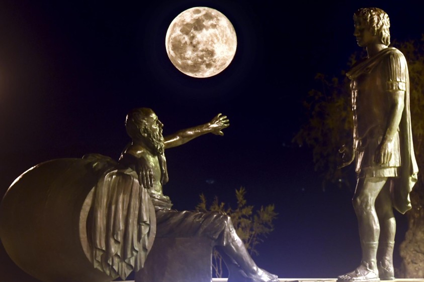 La Súper Luna de Nieve se levanta entre las estatuas de Alejandro Magno (D) y Diógenes de Sinope (I) en Corinto. Foto: AFP