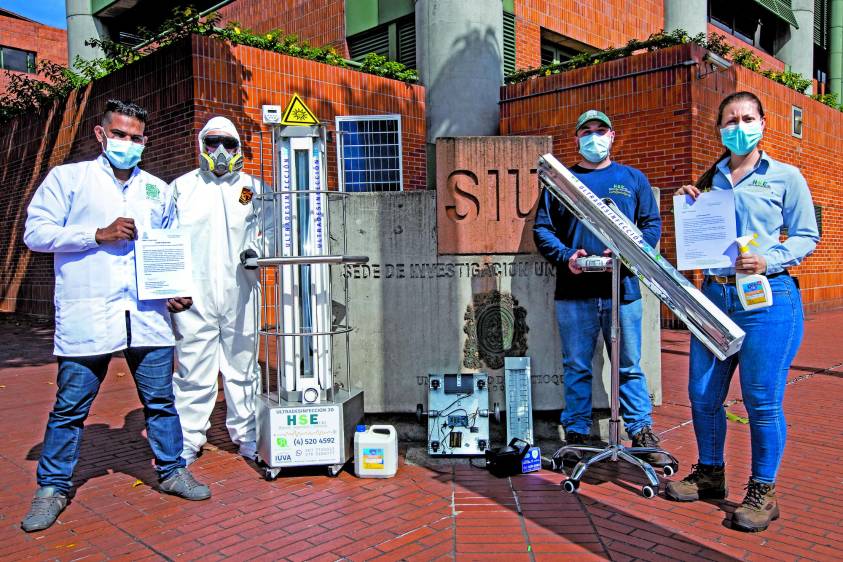 Juan David (primero) con sus compañeros y el robot que funciona con luz solar e inactiva al Sar-Cov-2 que hay en el país. FOTO Jaime Pérez
