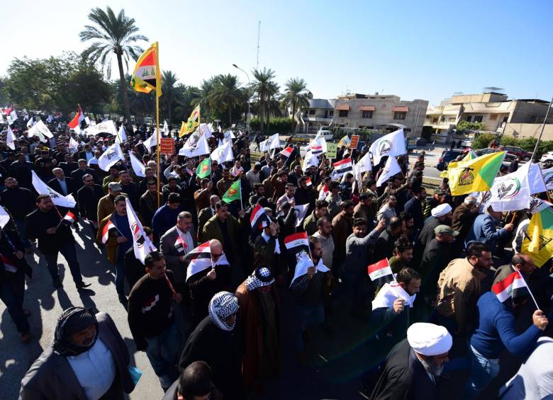 Manifestantes y simpatizantes ondean banderas mientras marchan hacia la embajada de los Estados Unidos. Foto: EFE.