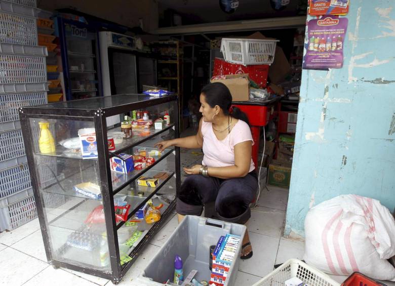 Una mujer reabre su negocio en la ciudad de Pedernales, una de las más afectadas por el terremoto. FOTO: REUTERS