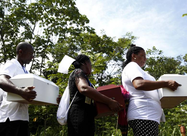 Un grupo de familiares ingresa a la antigua iglesia de Bojayá, lugar donde ocurrió la masacre en 2002, con los restos de las víctimas de la masacre de Bojayá. FOTO EFE