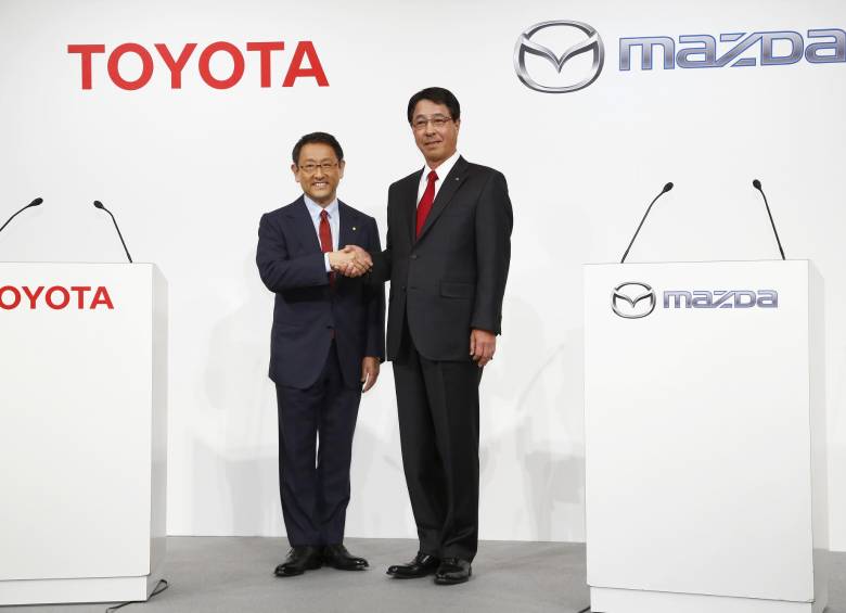 Akio Toyoda (izquierda), presidente de Toyota con su homólogo de Mazda, Masamichi Kogai. FOTO AFP