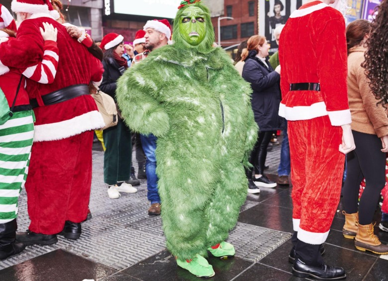 El Grinch, quien odia la Navidad, estuvo presente entre los Santa Claus. Foto GABBY JONES - Efe 