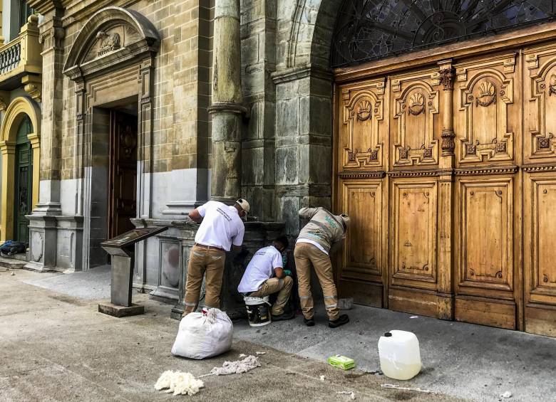 En las puertas centenarias de la Iglesia y en partes de la fachada pintaron consignas como “Niña, no madre” que promueven derechos de mujeres para decidir sobre su cuerpo. Aquí en la tarea de limpieza. FOTO julio césar herrera